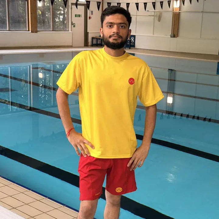 Lifeguard uniform bundle: yellow embroidered lifeguard t-shirt and red lifeguard shorts worn poolside